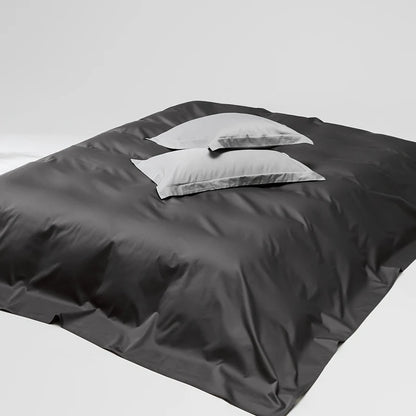 Dark gray bedding set with a white pillow on a white background
