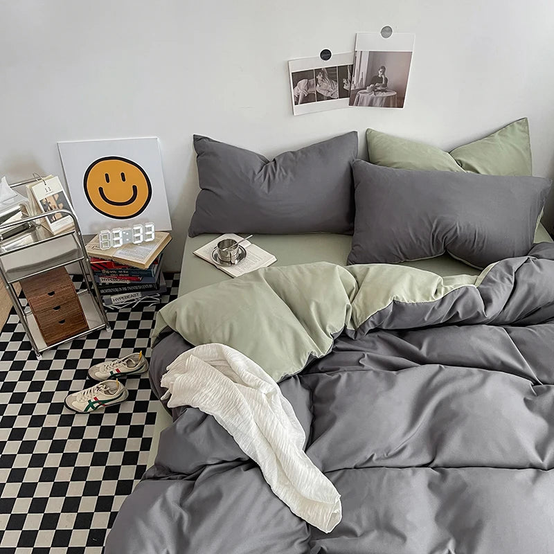 Gray and green bedding set on a bed with a checkered floor and decor items in the background.