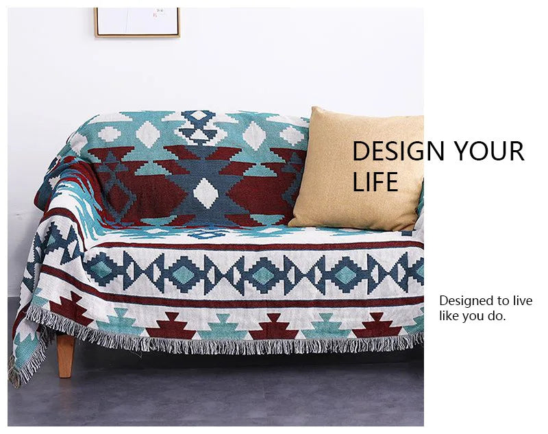 Geometric patterned throw blanket on a couch with a pillow, featuring motivational text.