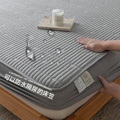 Gray waterproof mattress cover with a hand touching it, showing its texture and design.