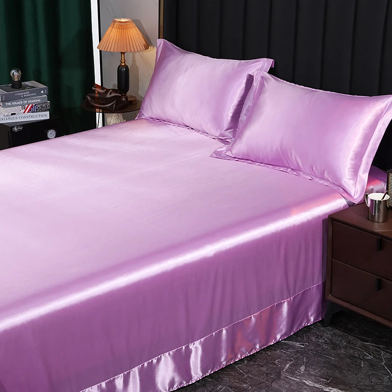 Purple satin bedding set on a bed in a bedroom setting.
