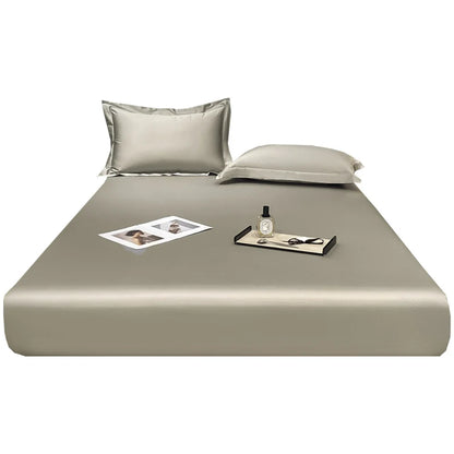 Beige bed sheet set with pillows on a white background