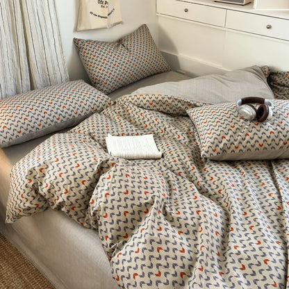 Patterned bedding set on a bed with pillows and a blanket