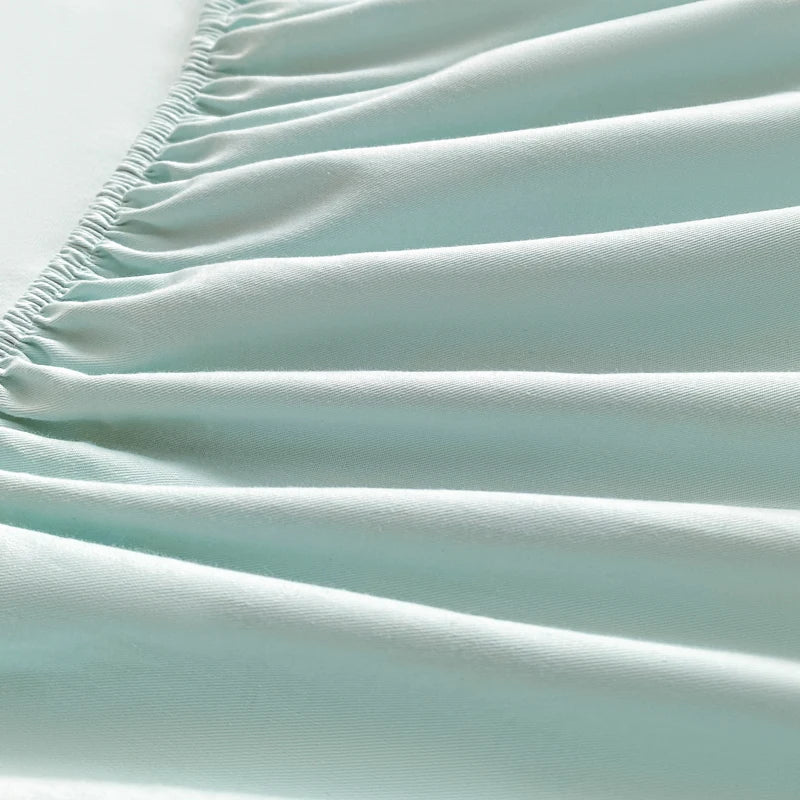 Close-up of a light blue fitted sheet with wrinkles on a white background