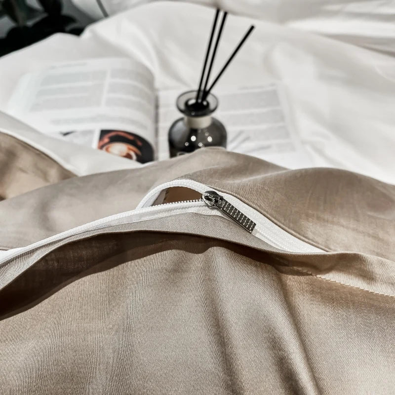Beige pillow with a zipper on a white surface, with a diffuser and book in the background.