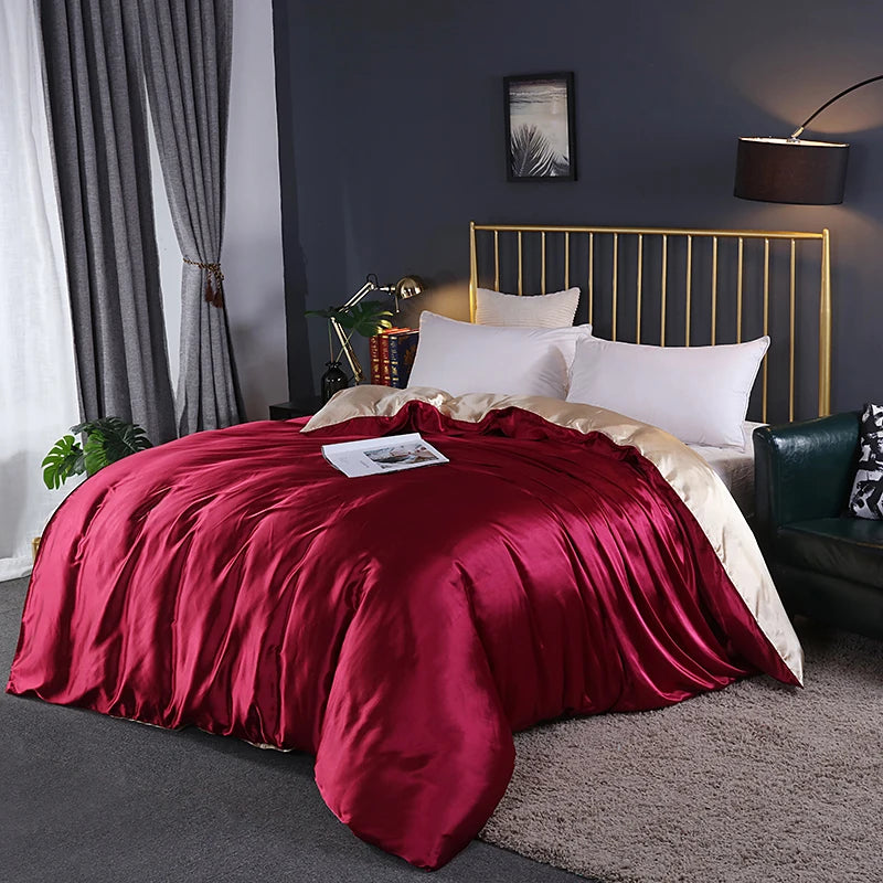 Bedroom with a bed covered in red satin sheets and gold headboard.