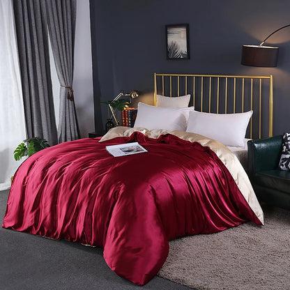 Bedroom with a bed covered in red satin sheets and gold headboard.