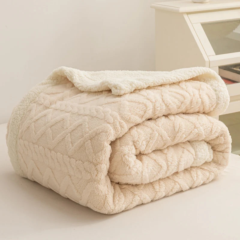 Folded cream-colored textured blanket on a light surface with a neutral background