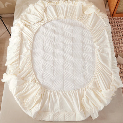 Round white cushion with ruffled edge on a light surface
