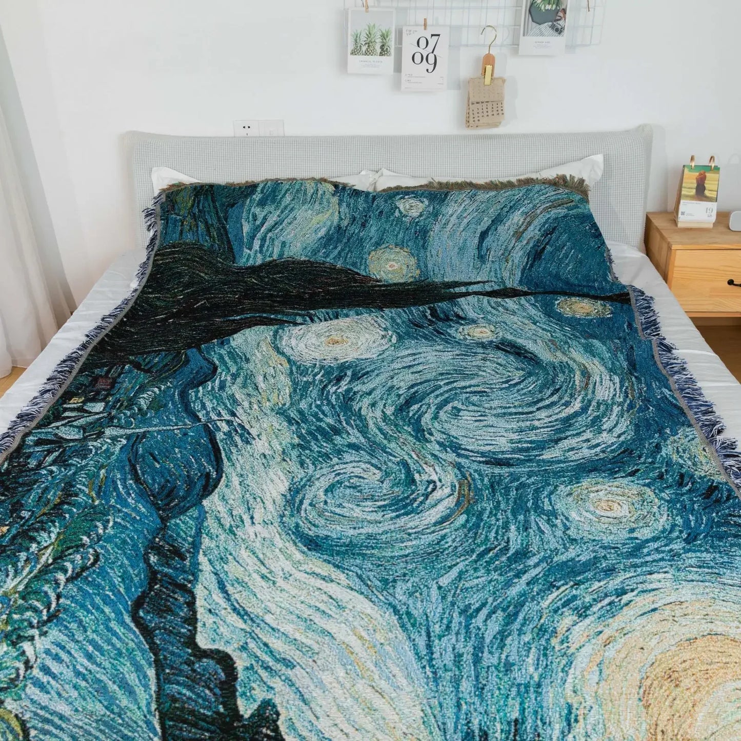 Bedspread with 'Starry Night' design on a bed in a bedroom setting.