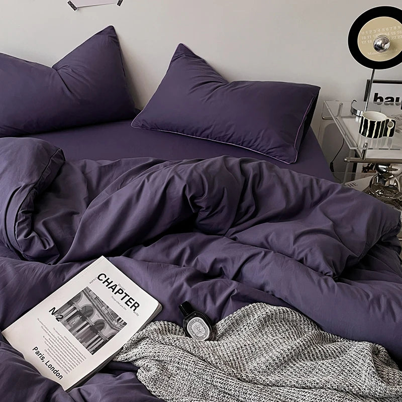 Purple bedding set on a bed with an open book titled 'Chapter' in the foreground.