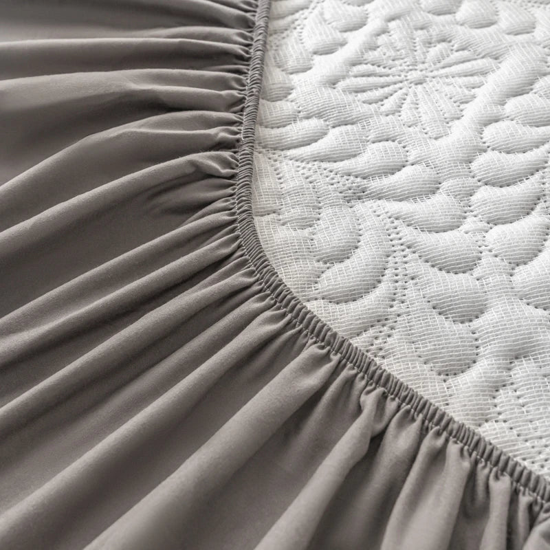Close-up of a fitted sheet on a mattress with a textured surface.