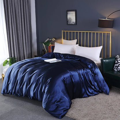Bed with blue satin comforter and gold headboard in a bedroom setting.