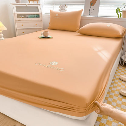 Orange bed sheet set on a bed with a visible brand logo in a bedroom setting.
