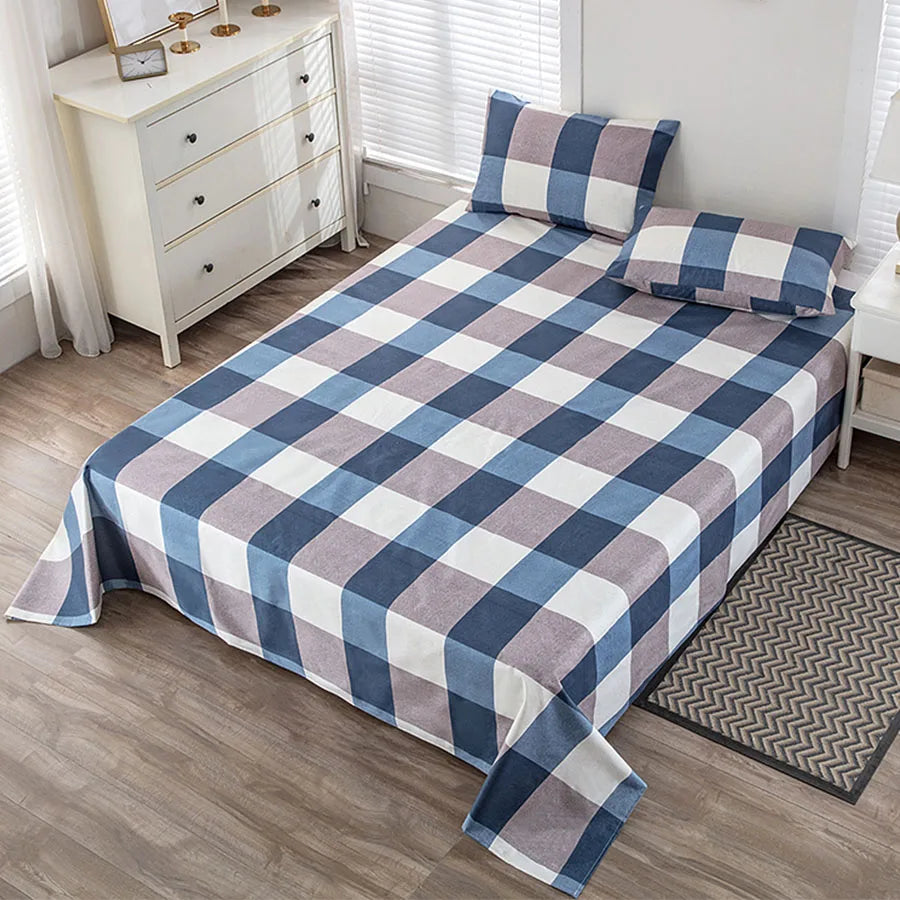 Bed with blue and white checkered comforter in a bedroom setting