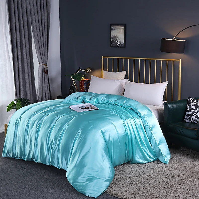 Turquoise comforter on a bed in a bedroom with dark walls and a gold headboard.