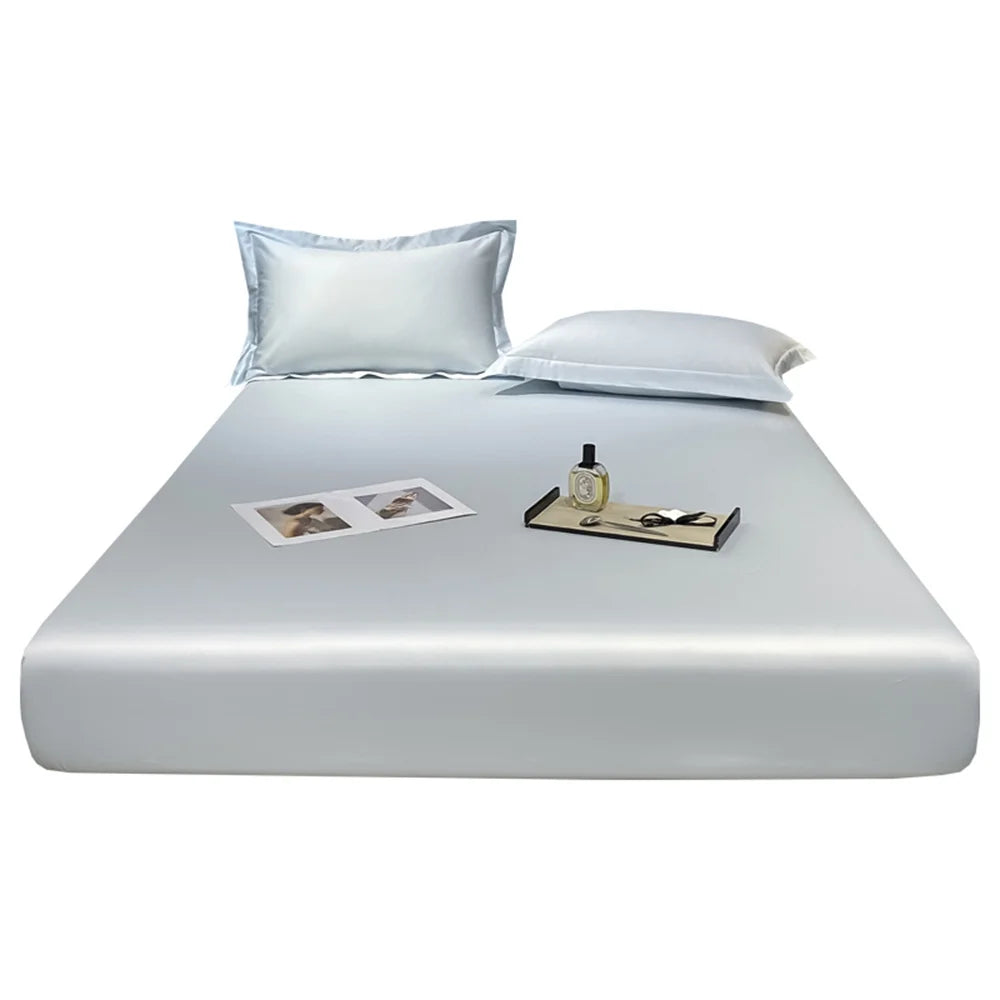 Silver reflective bed sheet set on a bed with a nightstand and photos.