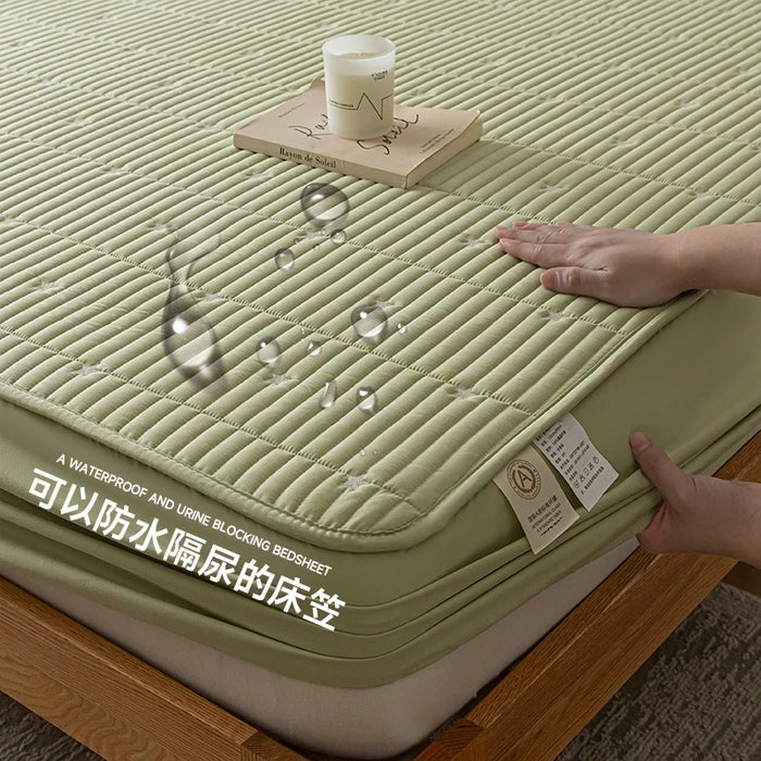 Green mattress cover with a hand touching it, showing its texture and waterproof feature.