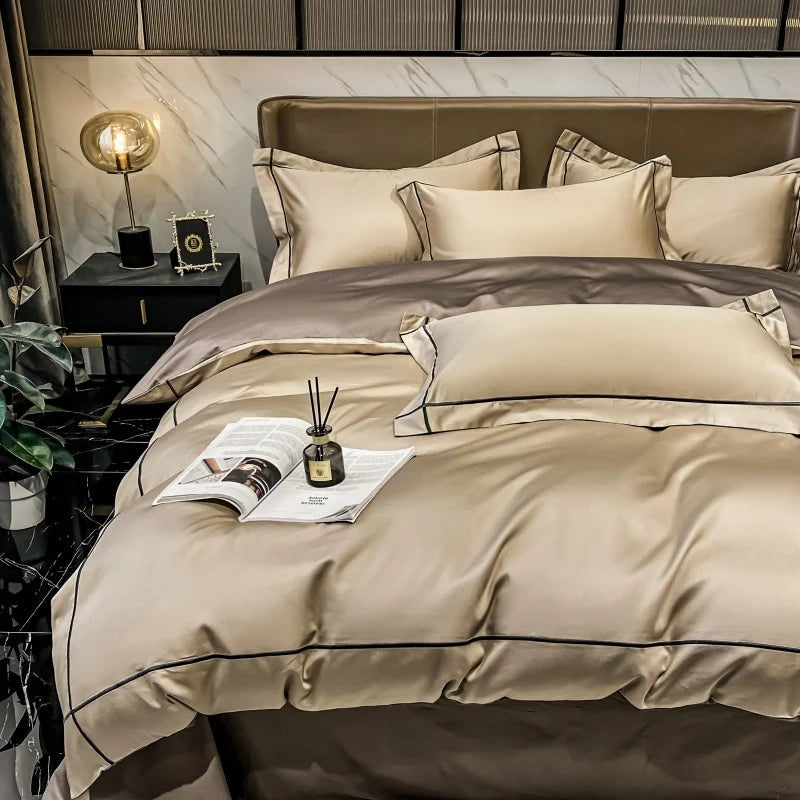 Beige bedspread set on a bed with decorative items in a bedroom setting.