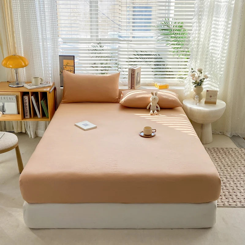 Beige bedspread on a bed in a bright room with curtains and decor.