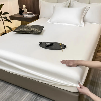 Person adjusting a fitted sheet on a bed in a bedroom setting.