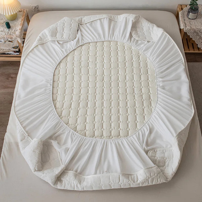 White mattress cover on a bed in a bedroom setting