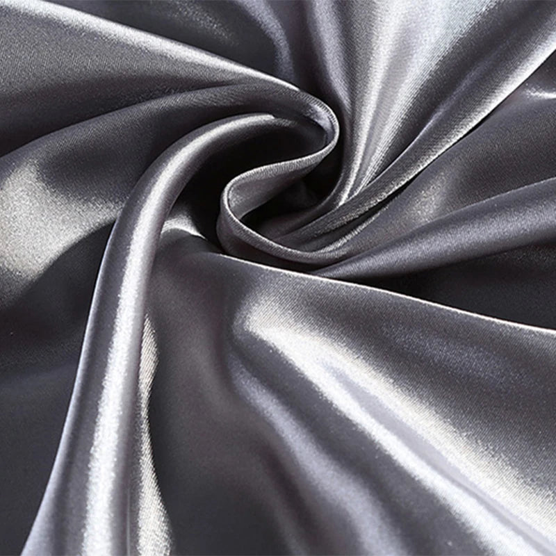 Close-up of silver satin fabric with folds