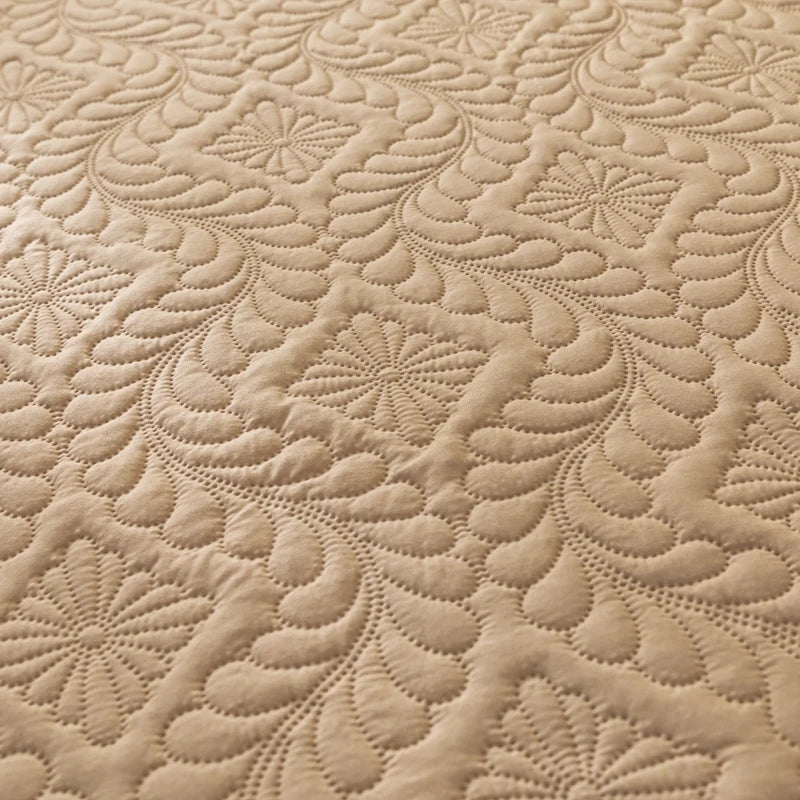 Close-up of beige quilted fabric with intricate pattern