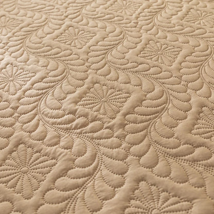 Close-up of beige quilted fabric with intricate pattern