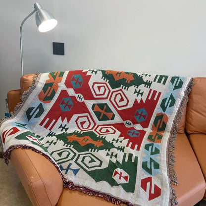 Colorful geometric patterned blanket draped over a brown sofa with a lamp in the background.