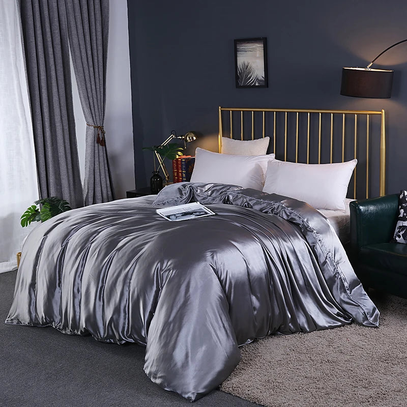 Bedroom with a bed featuring gray satin bedding, gold headboard, and decorative items.