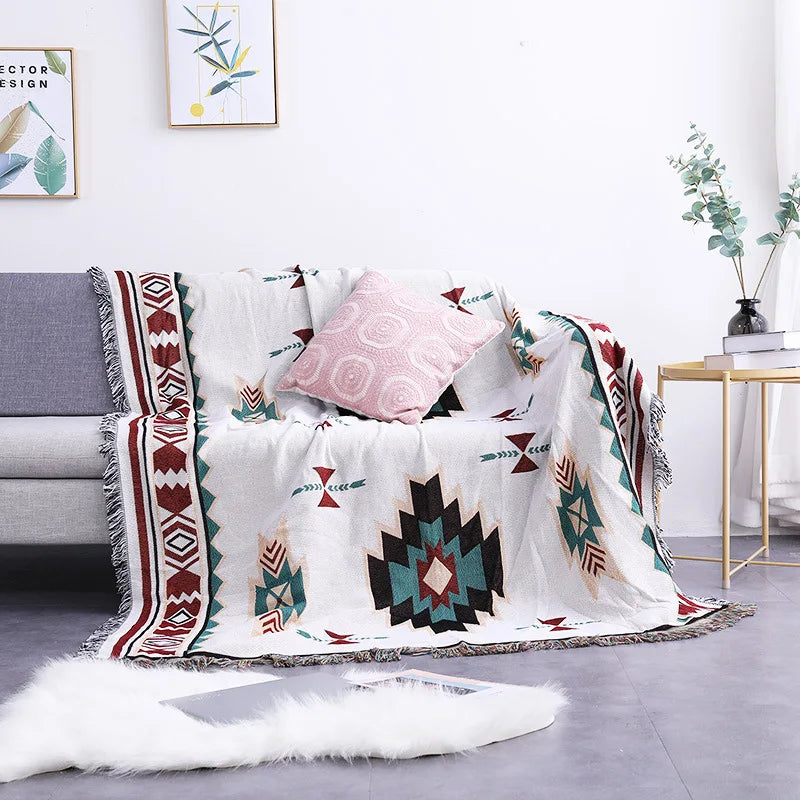 Decorative blanket with geometric patterns draped over a sofa in a living room.