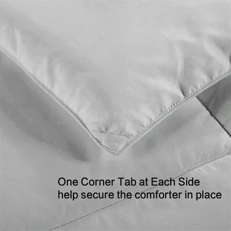 Gray comforter with corner tabs on a plain background