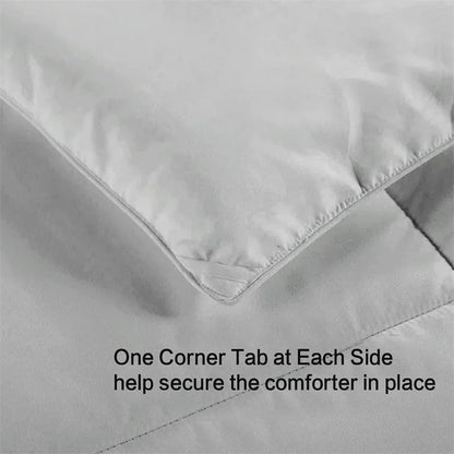 Gray comforter with corner tabs on a plain background