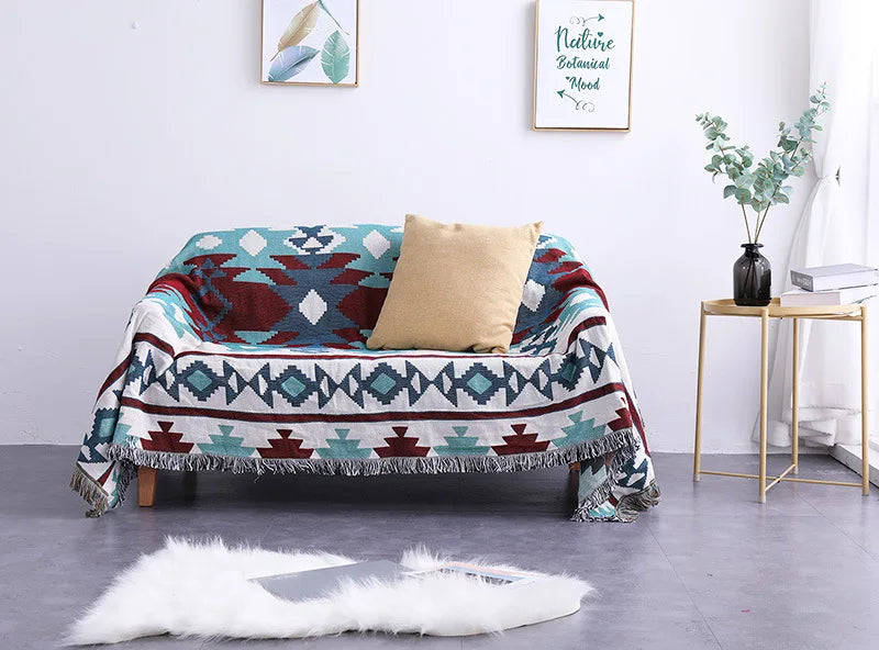 Colorful patterned throw blanket draped over a sofa in a living room setting.