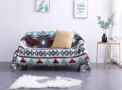 Colorful patterned throw blanket draped over a sofa in a living room setting.