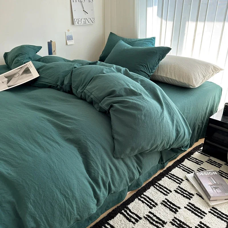 Teal bedspread on a bed in a bedroom with books and decor items.