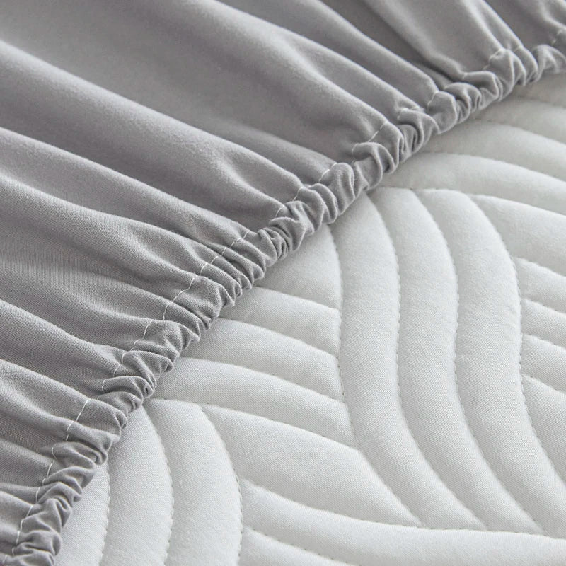 Gray fitted sheet on a mattress with a textured surface