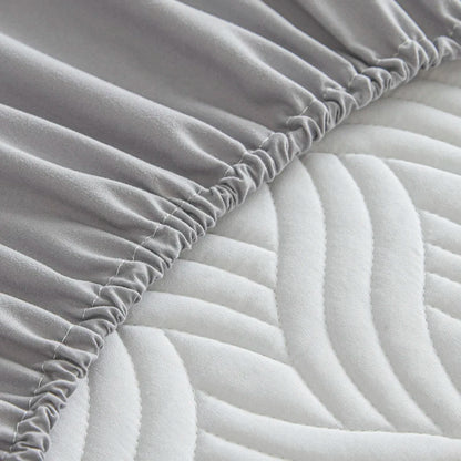 Gray fitted sheet on a mattress with a textured surface