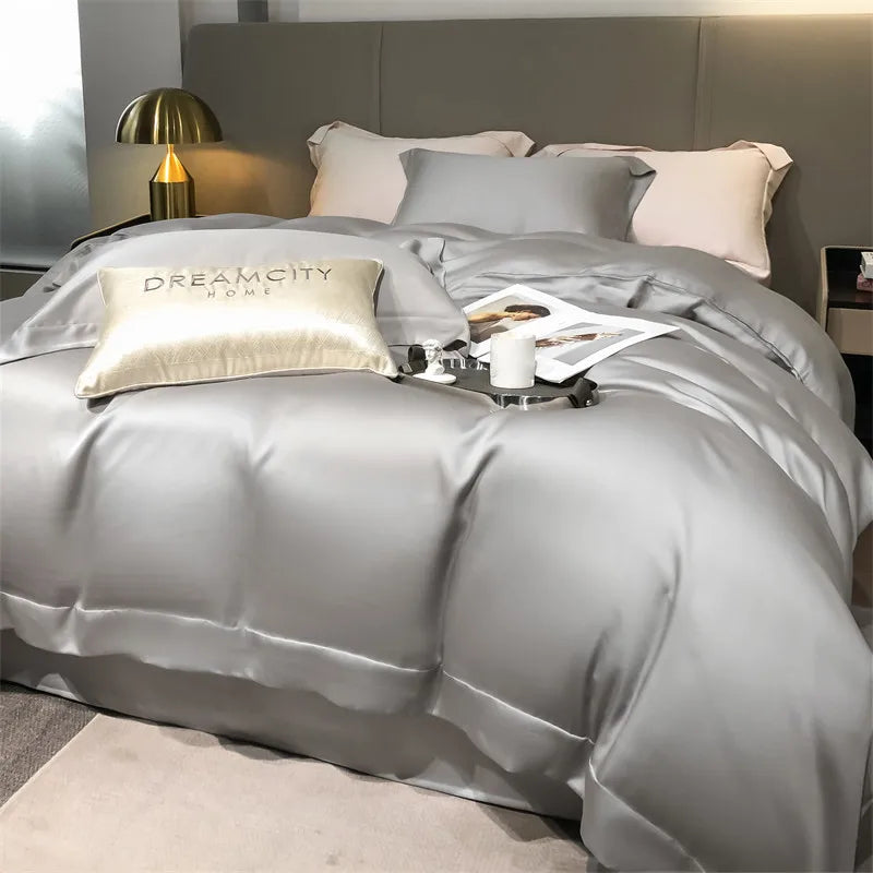 Gray bedding set with pillows and a lamp in a bedroom setting