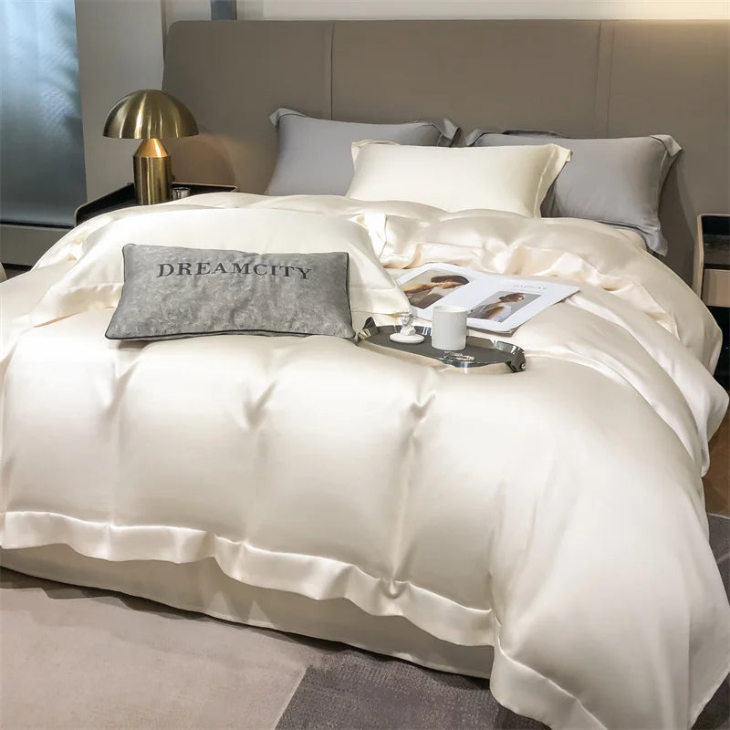 Neatly made bed with white bedding and gray pillows, featuring the brand 'Dreamcity'.