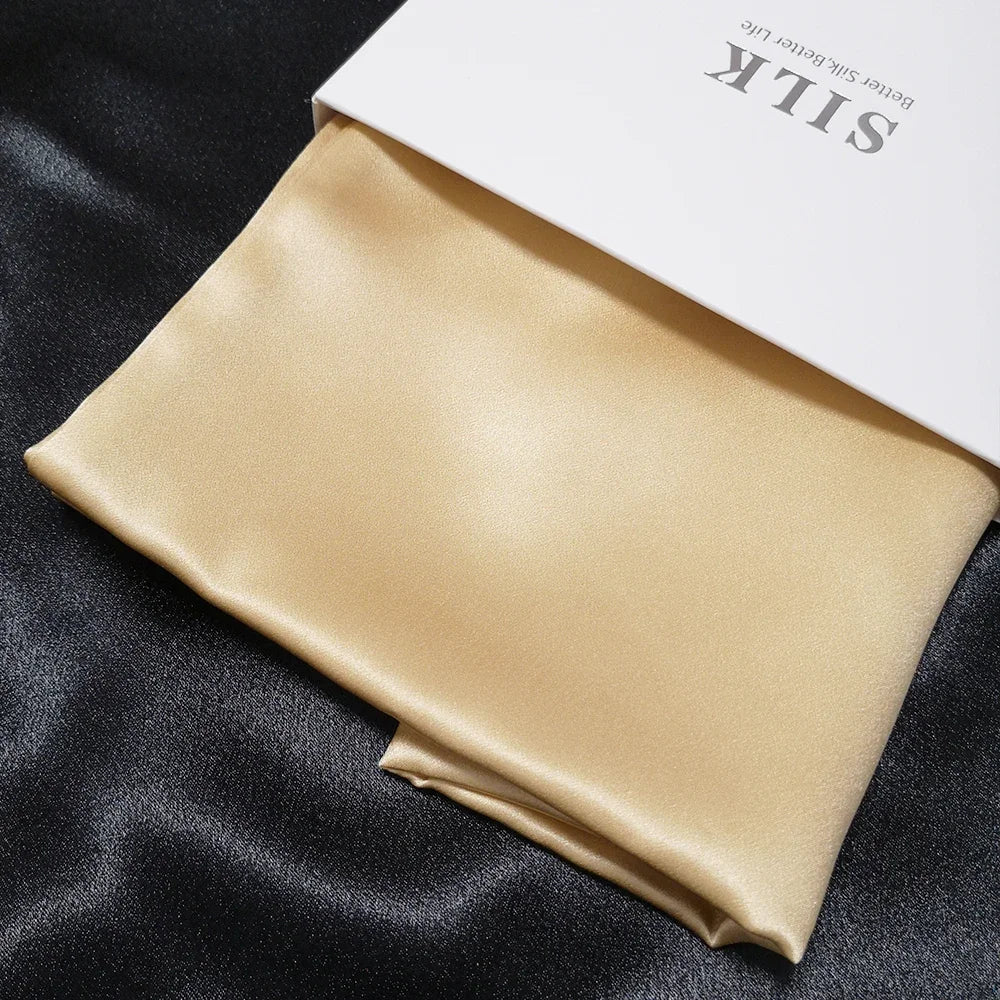 Beige satin pillowcase on a black fabric background with 'SILK' branding.