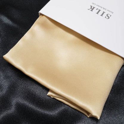 Beige satin pillowcase on a black fabric background with 'SILK' branding.