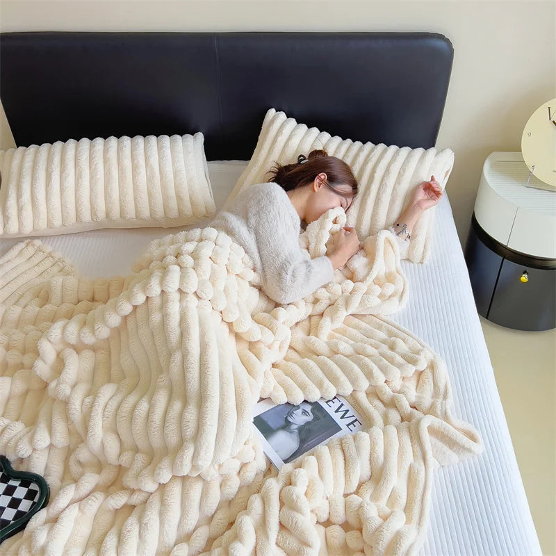 Person lying on a bed under a fluffy white blanket with pillows.