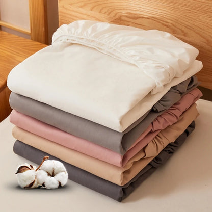 Stack of folded fabric sheets in various colors on a wooden surface.