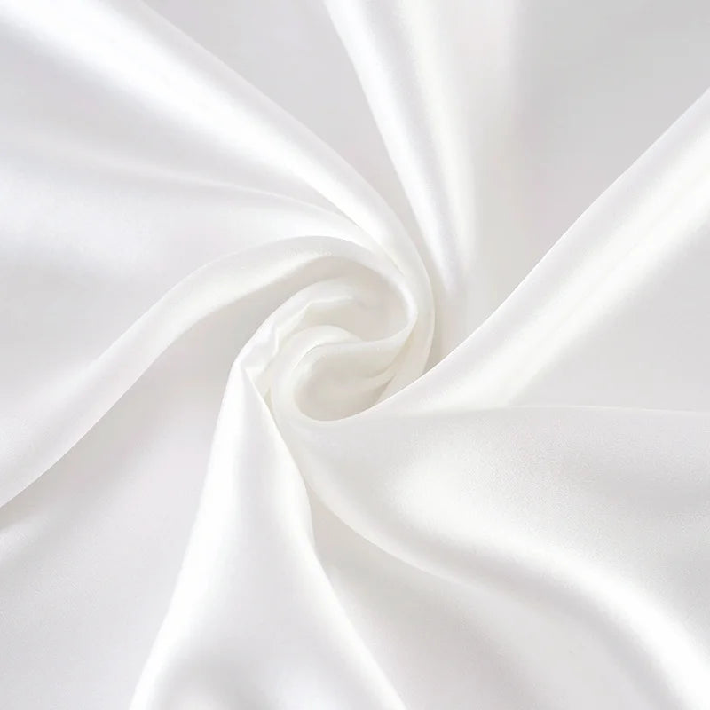 Close-up of white satin fabric with a subtle swirl pattern