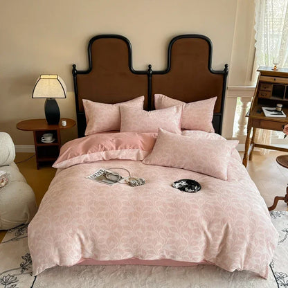 Pink floral bedspread on a bed with a wooden headboard in a bedroom setting.