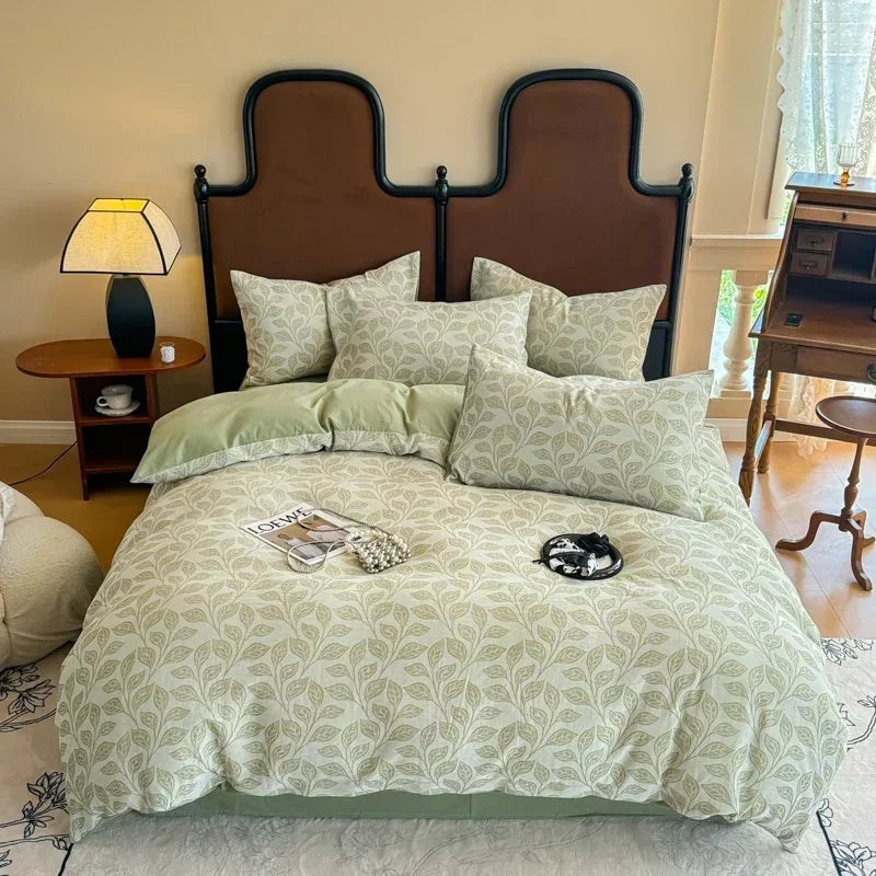 Bedroom with a bed featuring green and white bedding, a brown headboard, and a lamp on a nightstand.