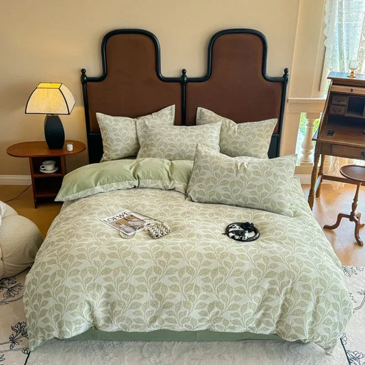 Bedroom with a bed featuring green and white bedding, a brown headboard, and a lamp on a nightstand.