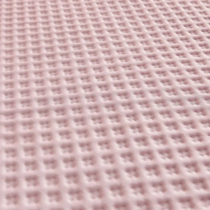 Close-up of a textured pink fabric with a grid pattern